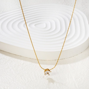 Elegant gold necklace featuring a star-shaped clear zircon pendant on a white tiered display