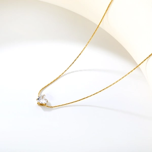 Macro detail of golden necklace with a claw-set heart-shaped clear cubic zirconia pendant