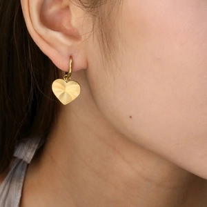 Boucles d'oreilles cœur plaquées or 18 carats avec motif soleil sur mannequin
