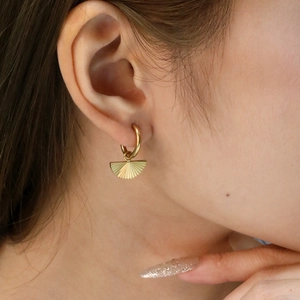 Macro d'une boucle d'oreille créole plaquée or 18K avec pendentif éventail plissé radial