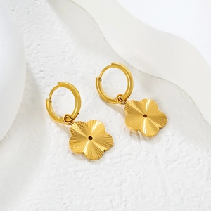 Vue macro détaillée de breloques florales en or 18 carats sur des boucles d'oreilles créoles