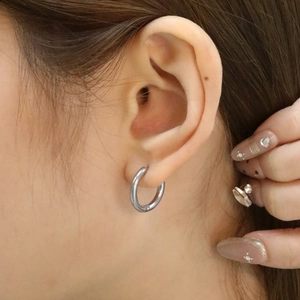 Boucles d'oreilles créoles classiques en acier inoxydable portées sur l'oreille