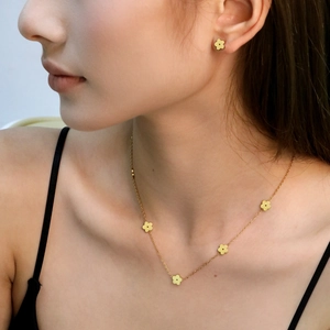 Elegant gold five-petal flower jewelry set including a necklace and matching stud earrings