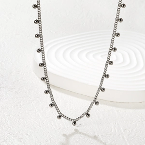 Detailed view of a silver-toned beaded chain necklace with small metal spheres