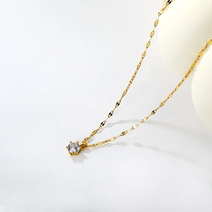Detail of 18k gold collar necklace featuring a single round zircon and flat oval links