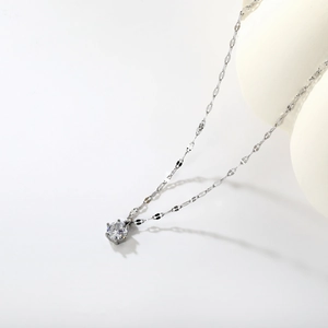 Detailed close-up of a minimalist 18k silver-plated chain necklace with a round zircon pendant