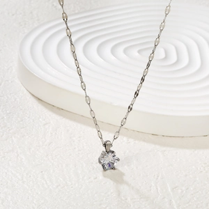 Classic silver necklace with a brilliant round-cut solitaire diamond on a white surface