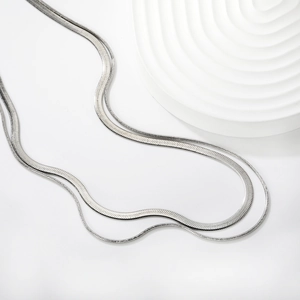 Macro detail of double-layered stainless steel necklace with flat herringbone and bead chains