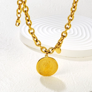 Close-up of gold chunky chain necklace with Elizabeth II coin pendant on a white base