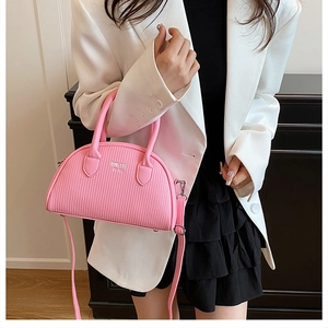Detail of pink shell-shaped crossbody bag with vertical pleated texture and zip closure