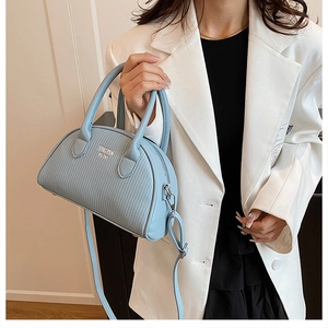 Close-up of light blue Boston shell bag with litchi texture and adjustable strap