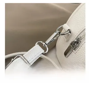 Macro view of white lychee leather texture and durable silver metal strap hook detail