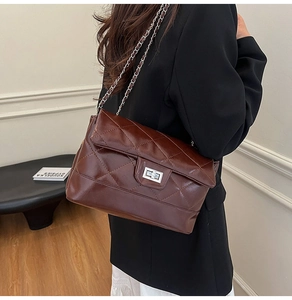 Détail du sac bandoulière matelassé marron foncé avec fermoir rotatif argenté