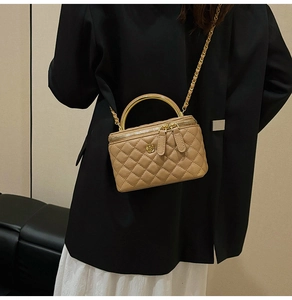 Detail of a quilted crossbody bag featuring a golden flower clasp and a metal top handle
