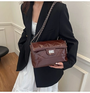 Détail du sac à bandoulière matelassé marron foncé avec fermoir rotatif argenté