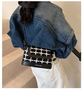 Detail of tweed check pattern shoulder bag with faux leather and knot strap detail