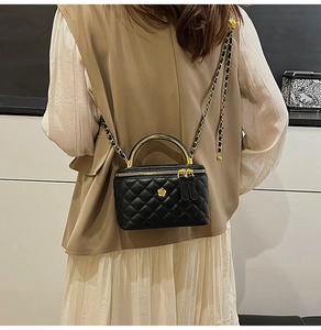 Quilted black leather mini vanity bag with gold chain strap and floral buckle detail