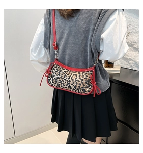 Leopard print shoulder bag with red bow details and glossy patent leather trim