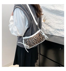 Detail view of the vintage leopard print crossbody bag with white bow ribbons and strap