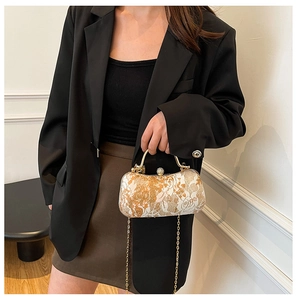 Detailed view of luxury jacquard evening bag with floral lock and gold metal handle