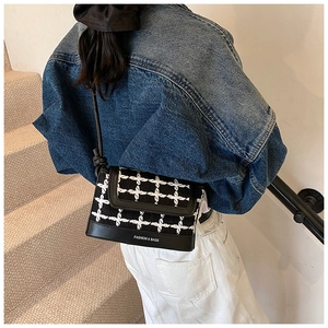 Detail of tweed and leather crossbody bag with FASHION & BAGS print on a female model