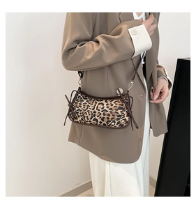 Detail view of leopard print baguette bag with brown side drawstring bow decoration