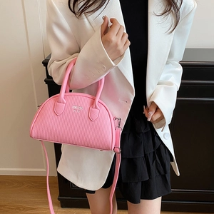 Pink textured leather shell bag with top handles and adjustable shoulder strap for women