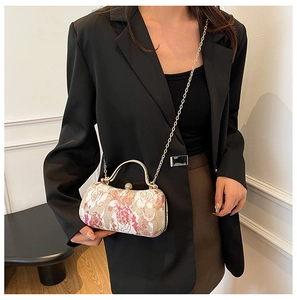 Close-up of vintage evening box bag with rose embroidery and pearl clasp detail