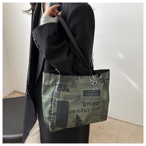 Détail du sac cabas gris-vert rétro avec imprimé journal et boucle en métal argenté