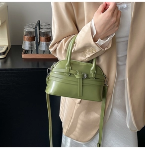 Detail of matcha green shell bag featuring decorative buckle and crossbody strap