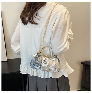 Detail of vintage floral embroidery evening bag with gold chain and pearl clasp