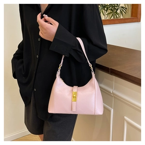 Detail showing diagonal quilted stitching and golden metal twist lock on pink handbag