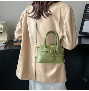 Close-up of avocado green shell bag featuring a knotted strap detail and adjustable handle