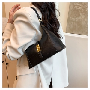 Close-up of black textured leather handbag featuring a polished gold-tone twist lock buckle