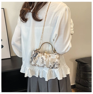 Detail of elegant gold evening bag with white flower sequins and sparkling chain strap