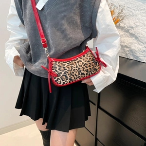 Vintage leopard print shoulder bag with red bow accents and patent leather straps