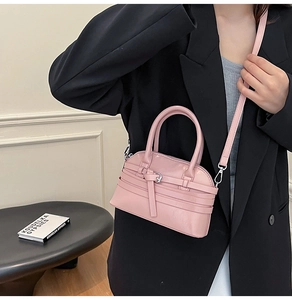 Detailed shot of pink glossy shell bag with silver hardware on a black suit outfit