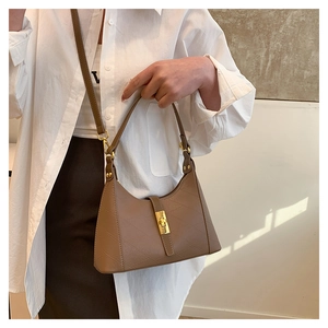 Brown leather half-moon shoulder bag with golden piston lock and quilted texture detail