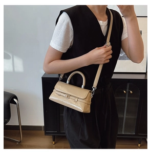 Beige patent leather crossbody bag shown on a model for everyday casual styling