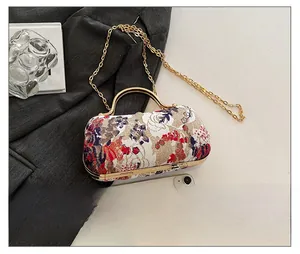 Detailed close-up of vintage floral jacquard bag with golden handle and fine chain strap