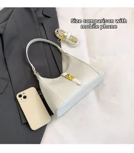 Phone size comparison of a creamy white hobo bag with gold metal buckle and strap