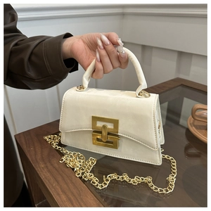 Détail du sac à main en cuir crème avec fermoir doré et chaîne en métal élégante