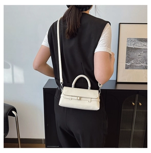 Cream crossbody bag shown on model in a modern minimalist interior setting