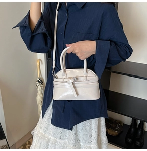 Crossbody shell bag in cream white PU leather with decorative belt detail and dual handles