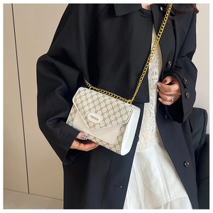 Sac bandoulière vintage porté, motif monogramme beige et boucle dorée Fashion élégante