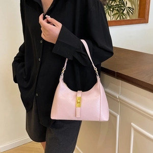 Pink leather crescent hobo bag with gold buckle and geometric pattern on a model