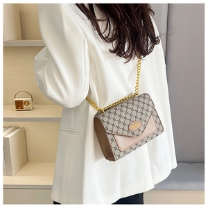 Détail du sac vintage avec motif monogramme et élégante bandoulière en chaîne