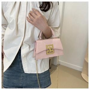 Détail du petit sac rose brillant avec bandoulière chaîne dorée et fermoir métallique