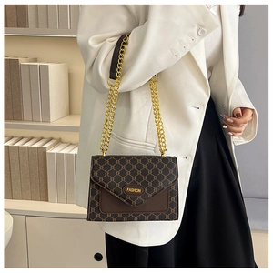 Détail du sac à motif vintage marron avec quincaillerie dorée fashion et bandoulière chaîne