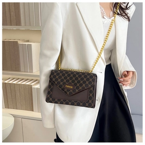 Détail du sac bandoulière vintage marron avec chaîne dorée et logo métallique
